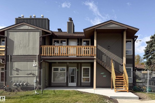 Front exterior of townhome building with wood siding, balconies, and stairs. - 5898 172 St Nw, Edmonton