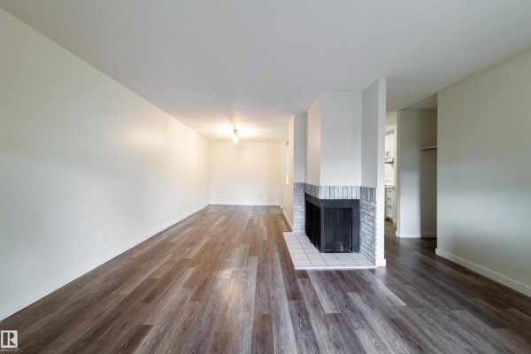 View from living room towards hallway, kitchen entrance, and fireplace. - 5898 172 St Nw, Edmonton