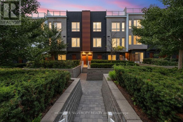 Pathway entrance to townhouses with landscaped hedges and trees. - 59 - 1359 Neilson Road, Toronto