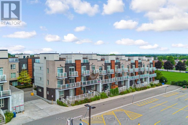 Aerial view of townhouses with balconies and surrounding parking lot. - 59 - 1359 Neilson Road, Toronto