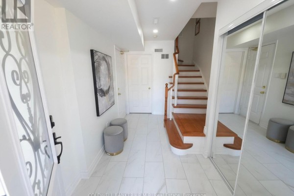 Interior foyer with white tile floors, a staircase with wooden steps, and mirrored closet doors. - 59 - 2 Hedge End Road, Toronto