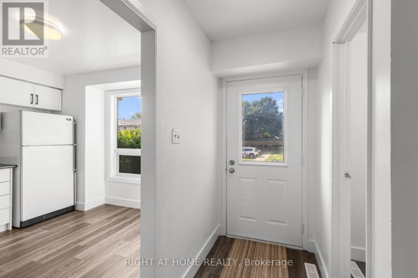 Kitchen with white cabinets, black countertops, white appliances, and a large window view. - 59 - 550 Second Street, London East