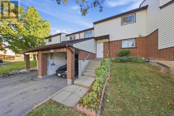 Exterior front view of a townhouse unit with a carport, brick base, and steps leading to the front door. - 59 - 880 Limeridge Road E, Hamilton