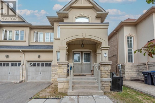 Close-up of the beige townhouse entrance with stone pillars, steps, and double doors. - 59 Beachville Circle, Brampton