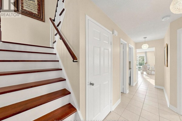 Hallway with wooden staircase and tile floor - 59 Brennan Road Ajax