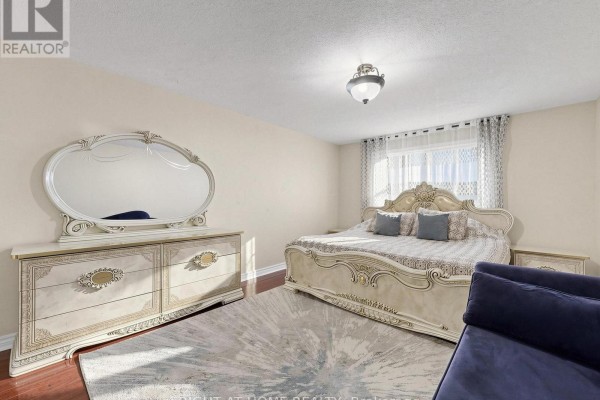 Ornate bedroom with bed, dresser, mirror, and rug - 59 Brennan Road Ajax