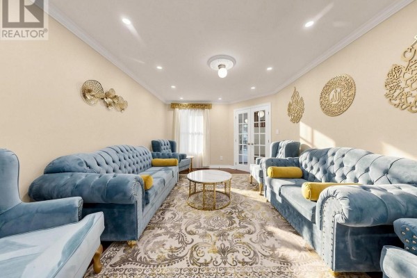 Living room with teal velvet sofas, armchairs, gold wall decor, and double doors leading to another room. - 59 Brennan Road, Ajax