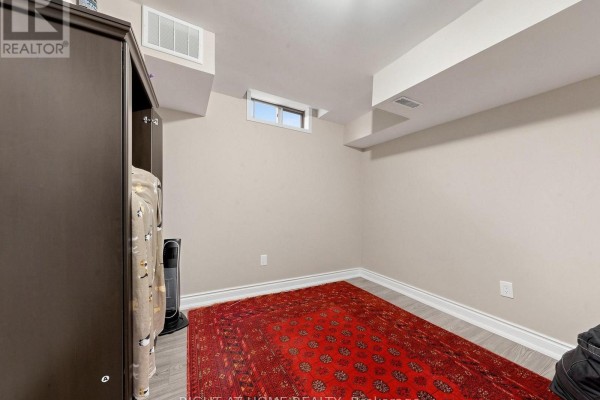 Basement room with oriental rug, wardrobe, and small window - 59 Brennan Road Ajax