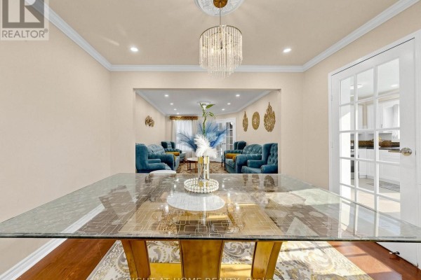 Glass dining table, crystal chandelier, and blue sofas - 59 Brennan Road Ajax