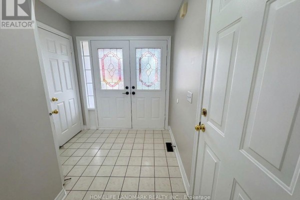 Interior entryway with white double doors, tiled floor, and grey walls. - 59 Checkerberry Crescent, Brampton