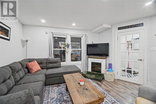 Backyard with green grass, wooden fence, tree, and an outdoor air conditioning unit. - 59 Freshwater Road, St  John S