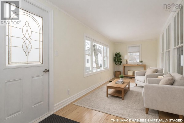 Sunroom with large windows allowing natural light and hardwood flooring - 59 Highway 201, Lequille