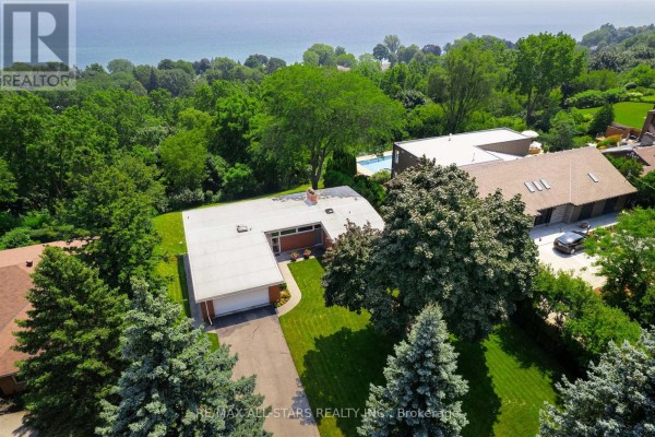 Overhead view of the U-shaped, single-story residence with a white flat roof and surrounding lush greenery. - 59 Hill Crescent, Toronto