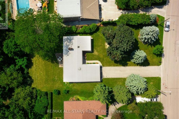Directly overhead drone view of the sprawling L-shaped, single-story house and its surrounding manicured lawn. - 59 Hill Crescent, Toronto