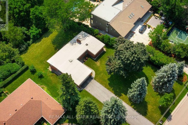 Aerial perspective of the unique U-shaped ranch-style home, its driveway, and mature landscaping in a suburban setting. - 59 Hill Crescent, Toronto