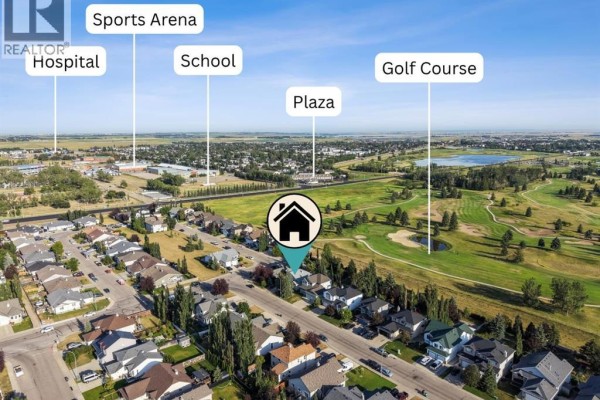 Aerial view of a residential neighborhood with labels pointing to a school, hospital, sports arena, plaza, and golf course. - 59 Hillview Road, Strathmore