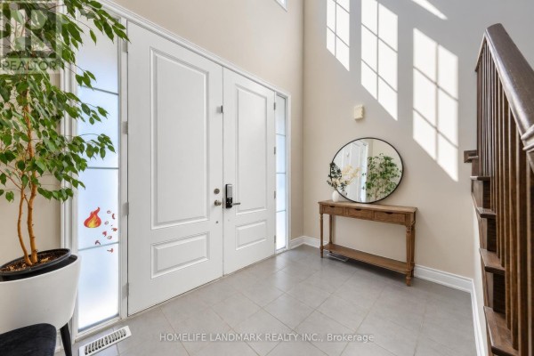 Bright foyer with double doors, tile flooring, a console table, and a potted plant. - 59 Hilts Drive, Richmond Hill