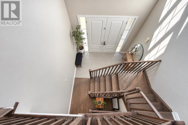 View from above showing a wooden staircase and the foyer with double doors and windows. - 59 Hilts Drive, Richmond Hill