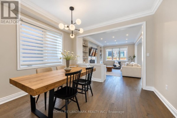 Dining area with a wooden table and chairs, open to a living room with a sofa. - 59 Hilts Drive, Richmond Hill