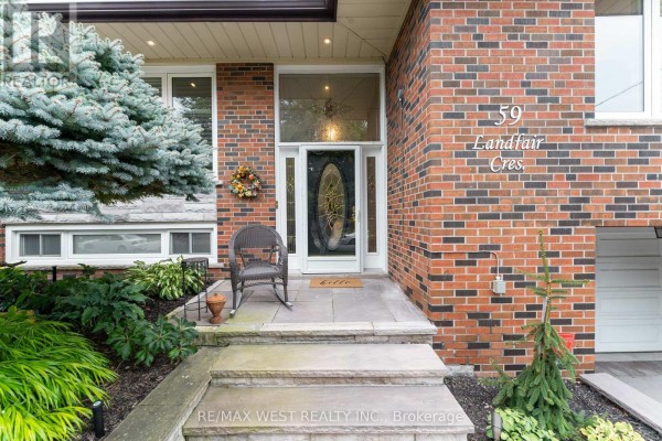 Front entrance with stone steps, rocking chair, and decorative glass front door. - 59 Landfair Crescent, Toronto