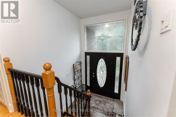 Interior view of the foyer showing the black front door with decorative glass panels. - 59 Landfair Crescent, Toronto