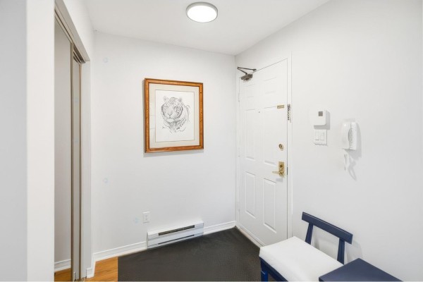 Apartment entryway with white walls, a white door, and a framed tiger drawing. - 59 Rue Des Carouges, #3, Gatineau