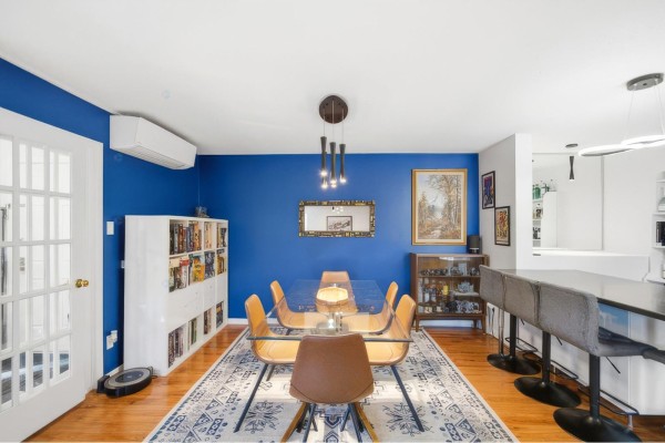 Dining area with a glass table, chairs, white bookcase, and a bar with stools. - 59 Rue Des Carouges, #3, Gatineau