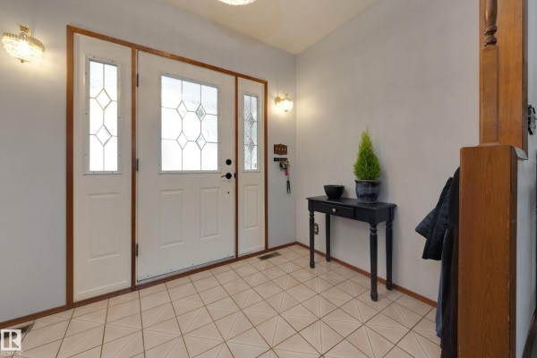Front entryway with a white door, sidelights, and beige tiled floor. - 59 Spruce Av, Sherwood Park