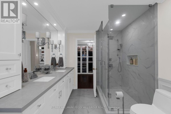Spacious bathroom with a double vanity, large mirror, and a glass-enclosed marble shower. - 590 Gagnon Place, Newmarket
