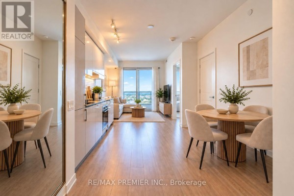 Dining area with a round wooden table and chairs, adjacent to the kitchen and living room. - 5901 - 950 Portage Parkway, Vaughan