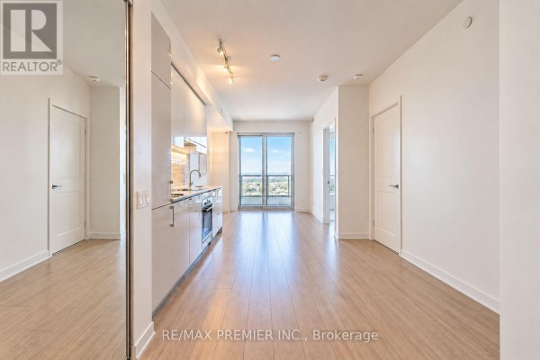 Hallway with doors leading to rooms, overlooking the open concept living space and kitchen. - 5901 - 950 Portage Parkway, Vaughan