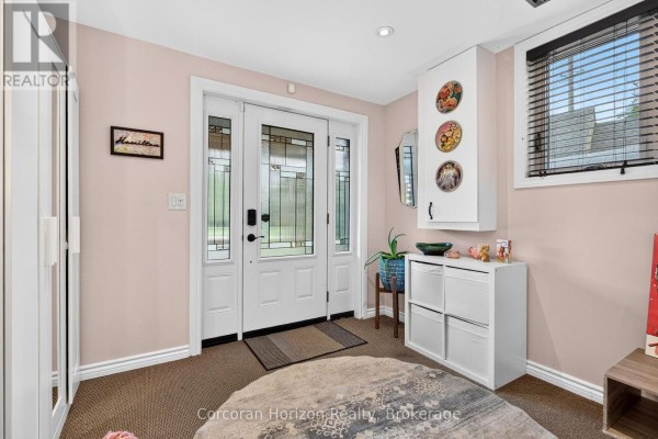 Interior view of a entryway with double glass doors, carpet, and white storage units. - 592 Aberdeen Avenue, Hamilton