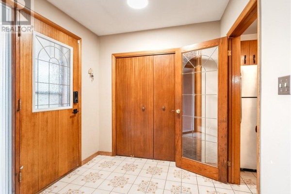 Entryway with tiled floor, wood closet doors, and glass-paned front door. - 593 Danforth Avenue, Sudbury