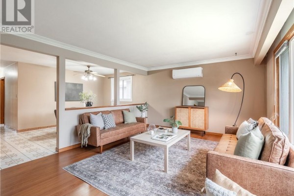 Living room with wood floors, open partition, and view into hallway and dining area. - 593 Danforth Avenue, Sudbury