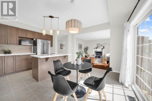 Modern kitchen with island and dining nook, view to living room with fireplace. 593 Pinawa Circle Ottawa