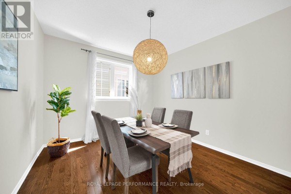 Dining room with a wooden table, grey chairs, and a large pendant light. - 593 Pinawa Circle, Ottawa