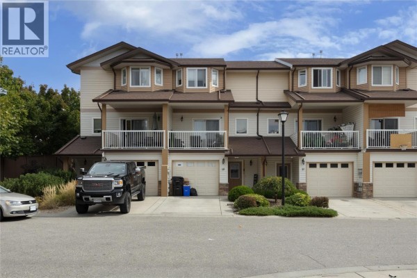 Exterior view of townhouse complex showing multiple units and a curving street. - 5951 Heritage Drive Unit# 10, Vernon