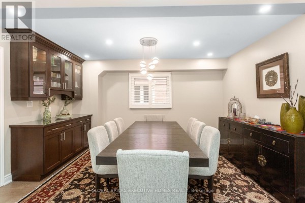 Dining room with dark wood table, upholstered chairs, buffet, and cabinetry - 5952 Grossbeak Drive Mississauga