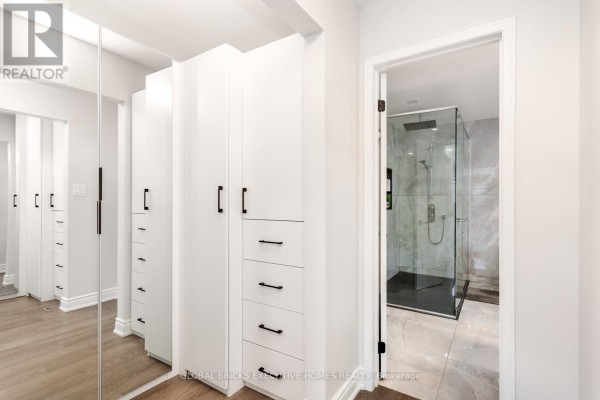White built-in cabinetry, mirrored closets, and glass shower - 5952 Grossbeak Drive Mississauga