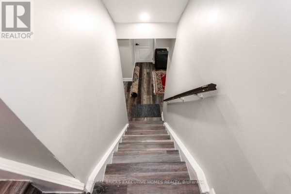 Staircase with wood-look flooring, handrail, and rugs - 5952 Grossbeak Drive Mississauga