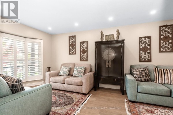Living room with bay window, dark cabinet, and sofas - 5952 Grossbeak Drive Mississauga