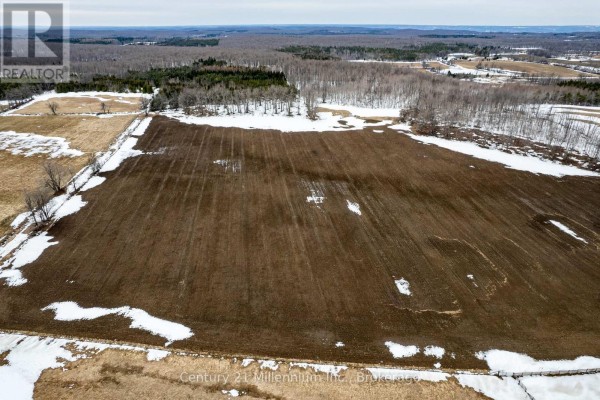 Aerial view of a section of the property lot showing rows in the tilled soil and surrounding trees. - 595298 4th Line, Blue Mountains