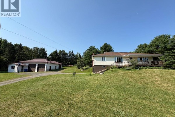 Aerial view of a residential property with a house and detached garage surrounded by trees. - 596 165 Route, Riceville