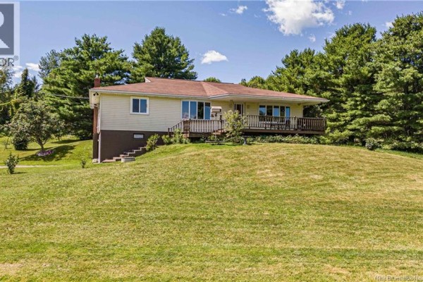 Rear exterior of the house showing a brick chimney and a single garage door. - 596 165 Route, Riceville