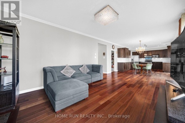 Open-concept living room with sectional sofa, hardwood floors, and modern kitchen - 596 Anjana Circle Ottawa