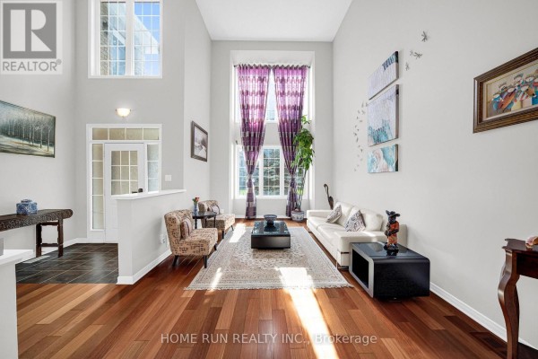 Living room with hardwood floors, high ceilings, large windows with purple curtains, and a white sofa. - 596 Anjana Circle, Ottawa
