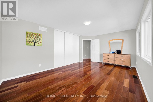 Bedroom with hardwood floors, dresser with mirror, and sliding closet - 596 Anjana Circle Ottawa