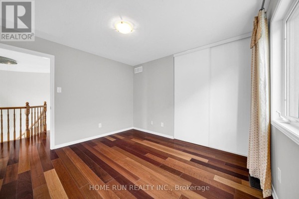 Hallway with hardwood floors, closet doors, and staircase - 596 Anjana Circle Ottawa