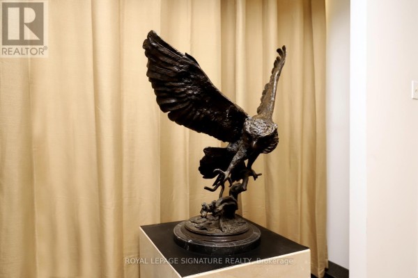 Bronze sculpture of an eagle in flight displayed on a dark marble pedestal against a beige backdrop. - 5a - 2740 Matheson Boulevard, Mississauga
