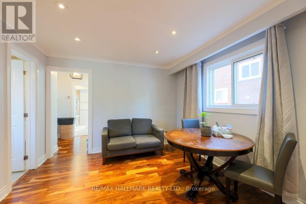 Room with a small sofa, dining table, and chairs, with wooden floors. - 5a Scotia Avenue, Toronto